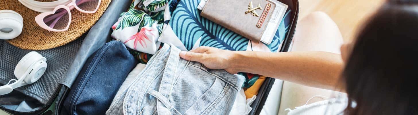 Woman packing a suitcase to go on holiday