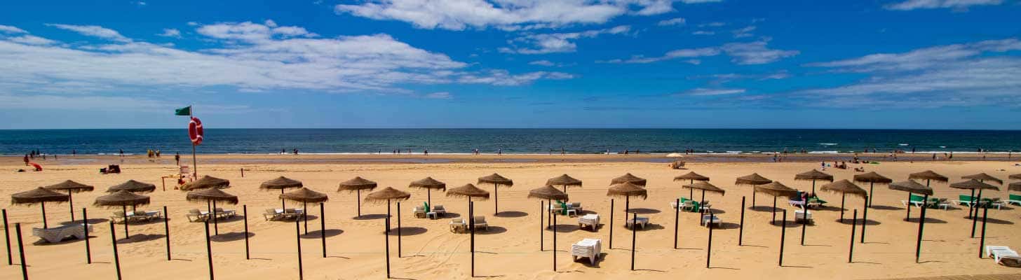 Sun umbrellas on the golden sands of Montegordo beach in the Algarve
