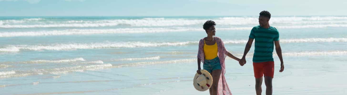 Couple walking hand-in-hand on a beach