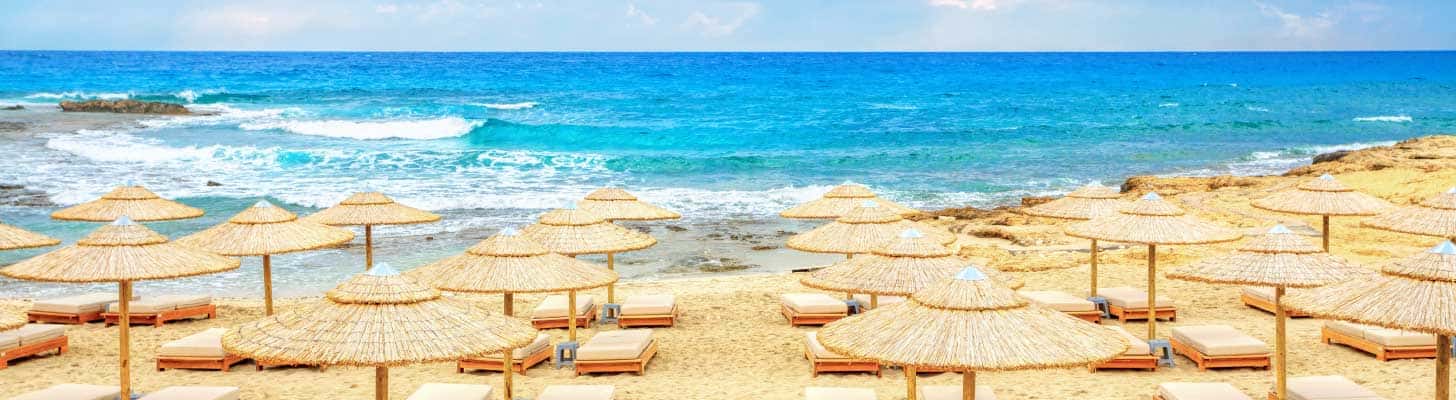 Sun umbrellas & loungers on the golden sands of Ayia Napa, Cyprus