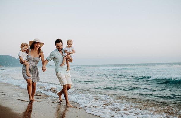 Family on beach walking through the waves